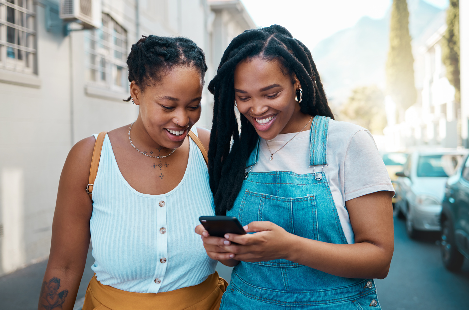 Happy Black Woman, Friends and Phone in Social Media Communication, Texting Together outside an Urban Street. African Women Smiling for 5G Connection in Canada Browsing, Chatting on Mobile Smartphone