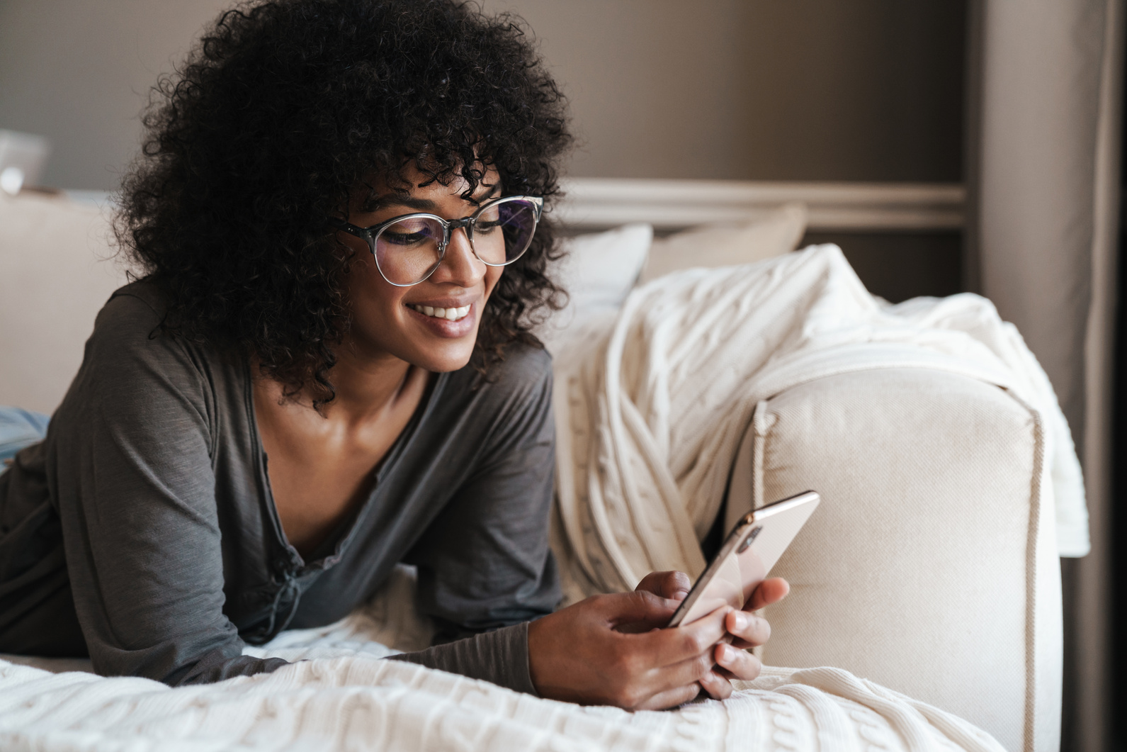 Smiling Young African Woman Using Mobile Phone