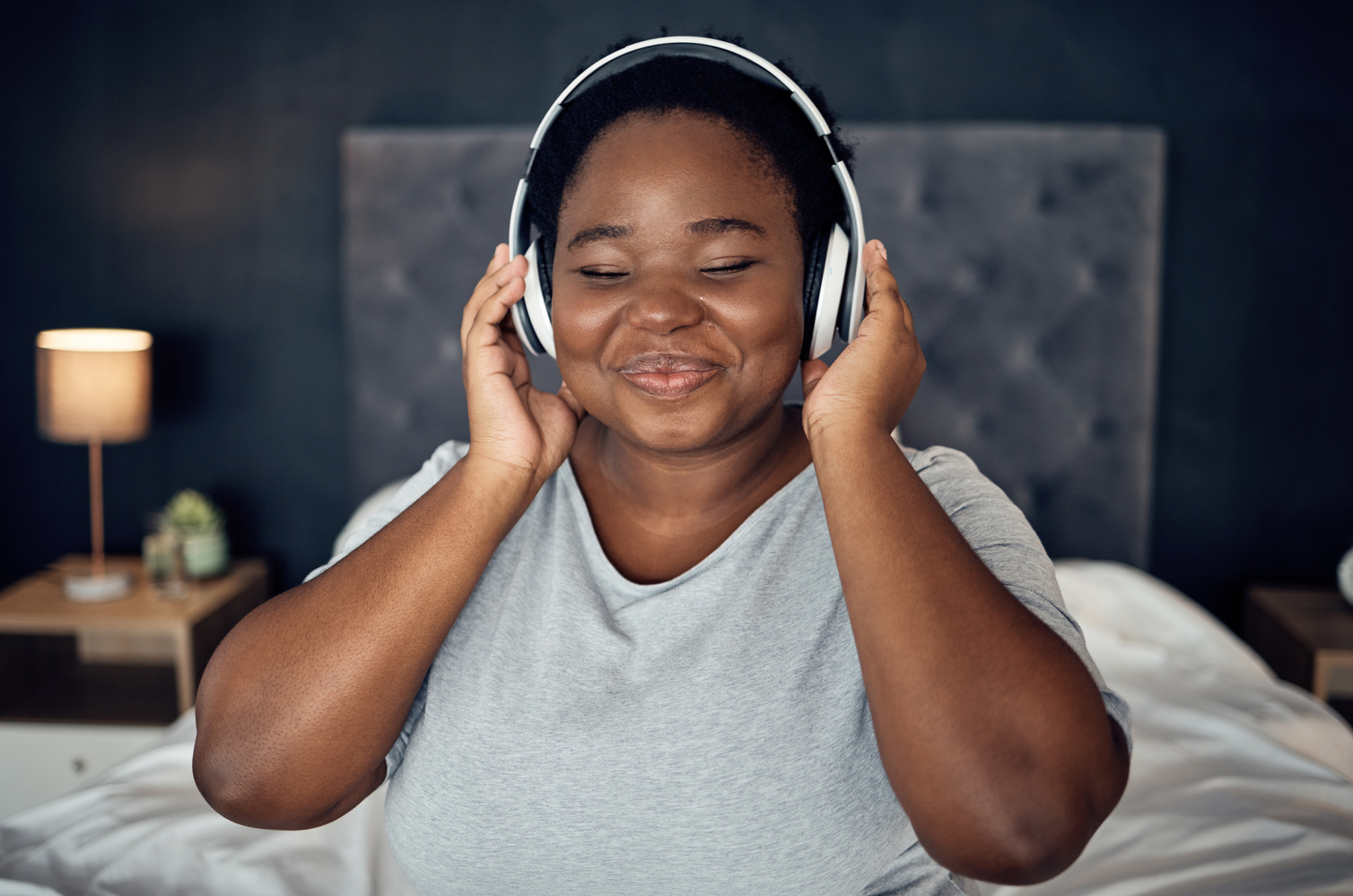 Crying, Smile and Black Woman with Headphones for Music, Sound or Audio. Tears, Radio and plus Size African Person Listening, Hearing and Streaming Podcast for Peace or Relax in Home Bedroom at Night