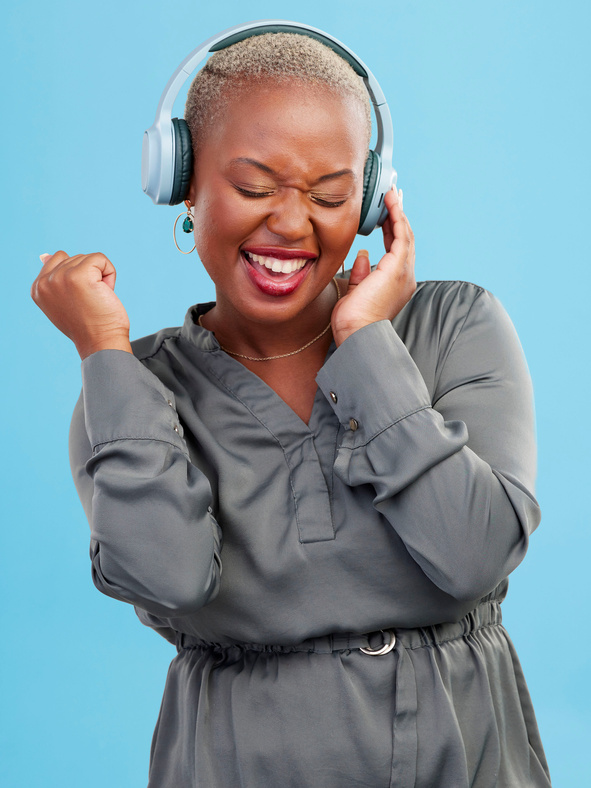 Happy Black Woman, Headphones and Listening to Music, Audio Track or Sound against a Studio Background. Excited African Female Person Smile Enjoying Podcast, Streaming or Entertainment on Headset