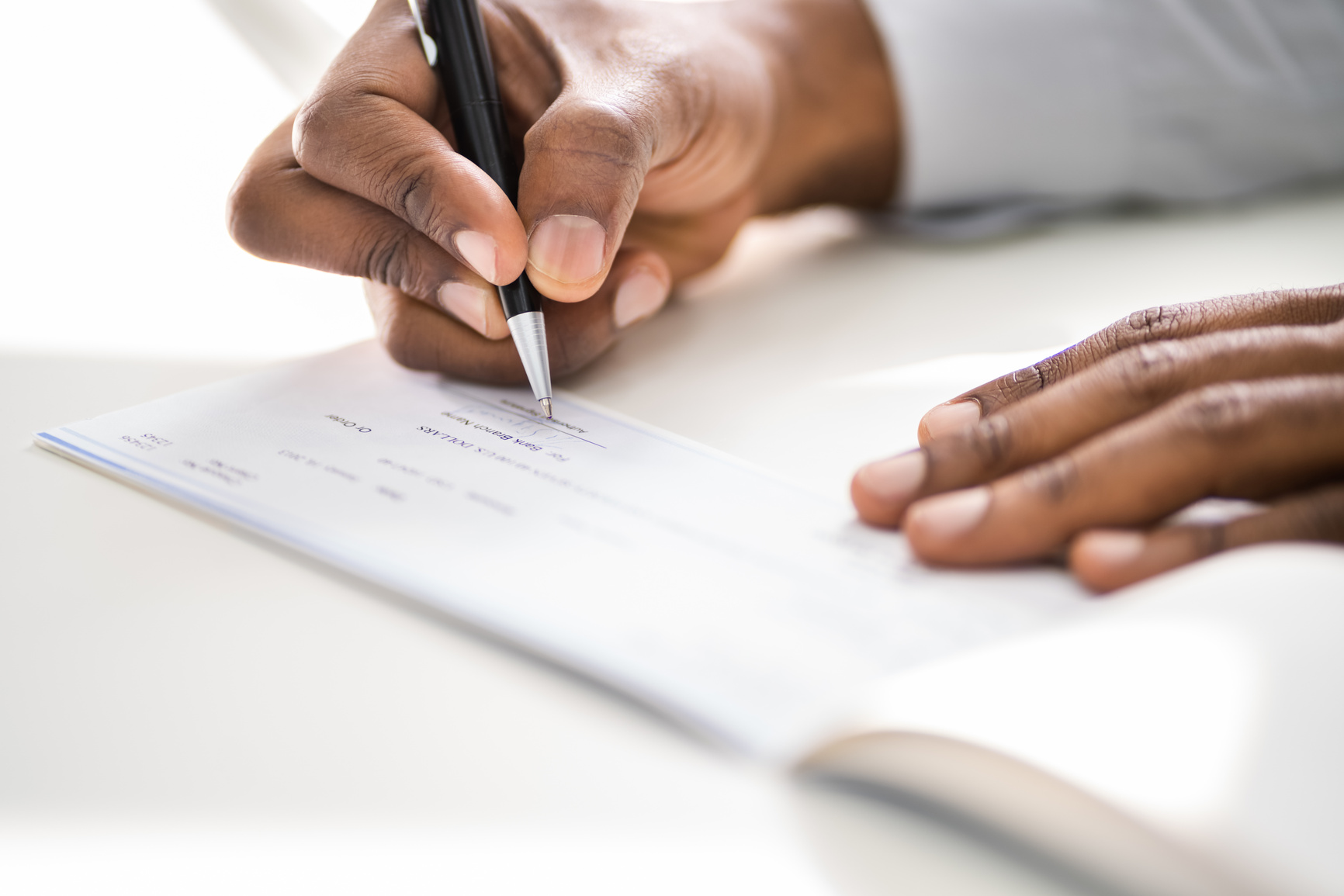 African American Writing Cheque. Signing Paycheck