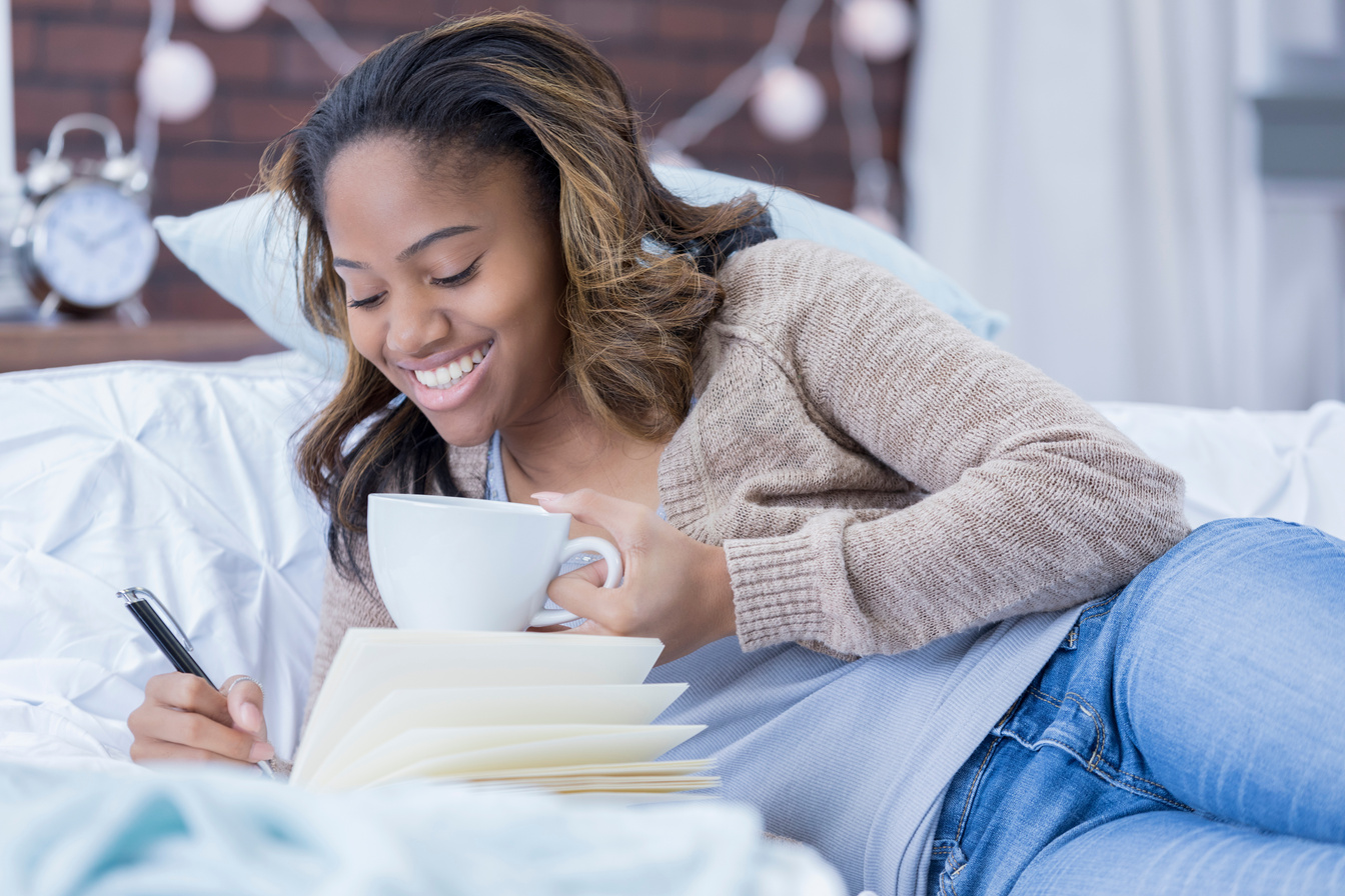 African American woman writes in journal