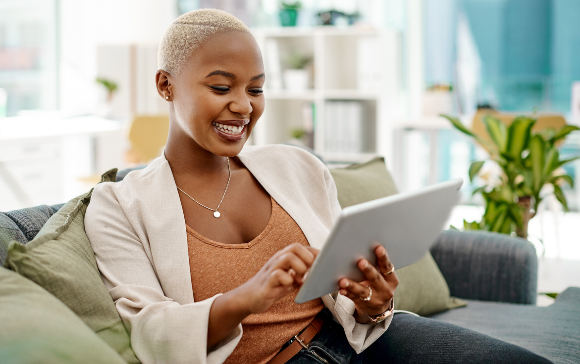 Happy, Tablet and Black Woman on Couch for Communication, Research and Relax in Modern Office. Female Assistant, Digital Technology and Scrolling on Sofa for Social Media, Contact and Networking