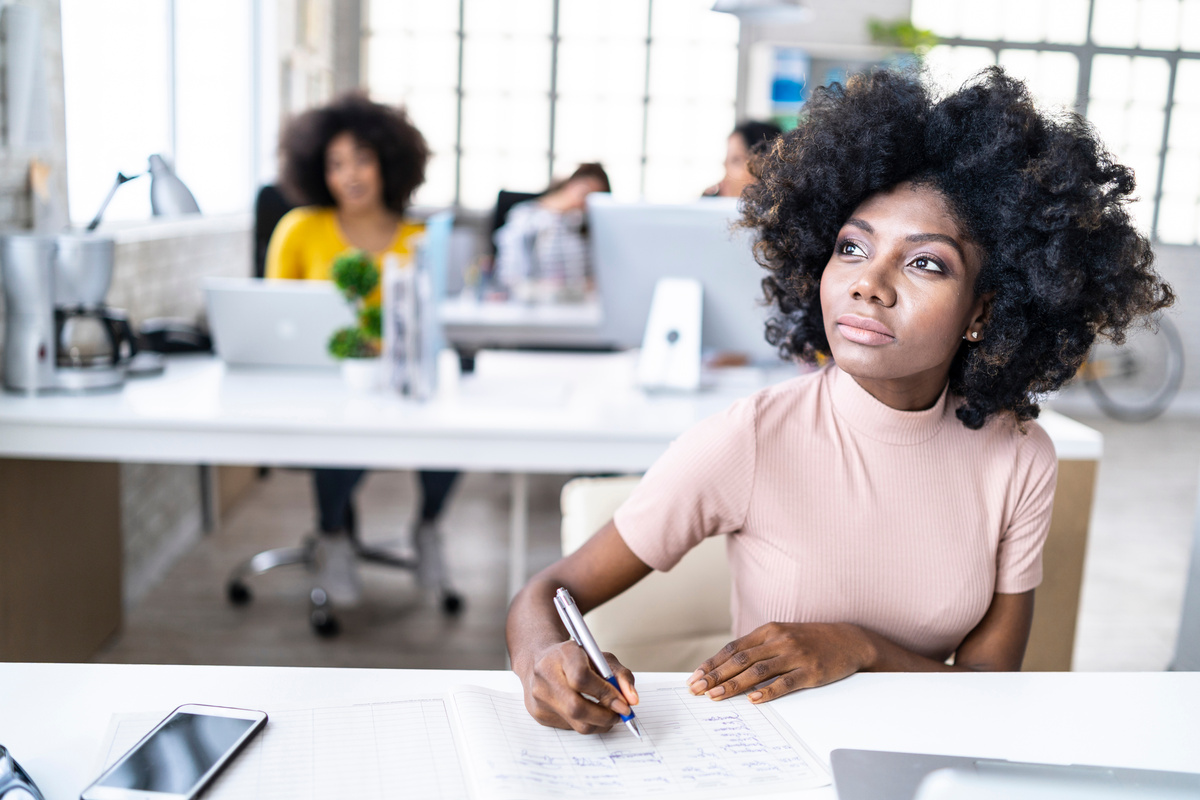 African woman writing and thinking